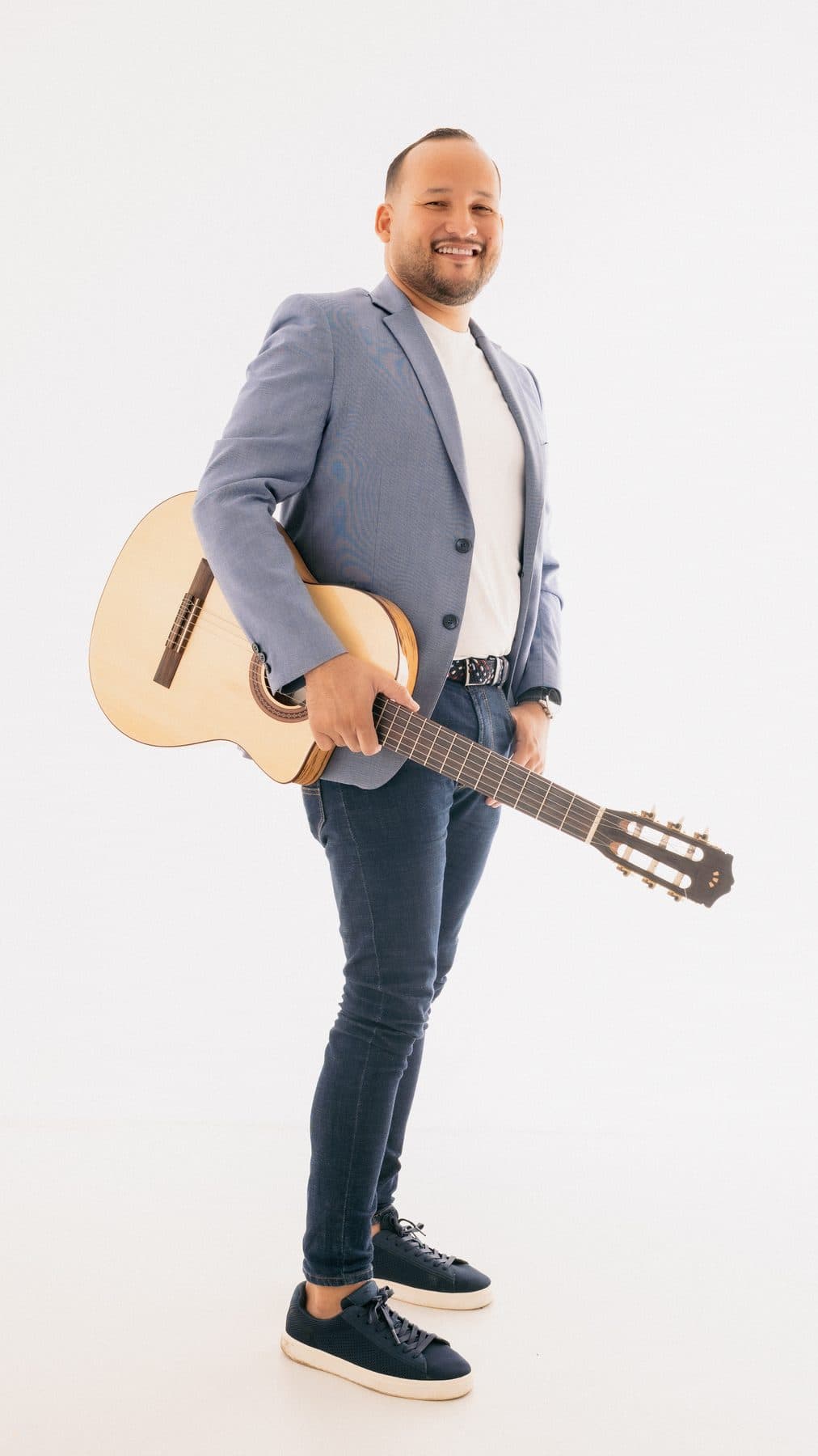 Juan Cañas de pie con guitarra en sesión de estudio
