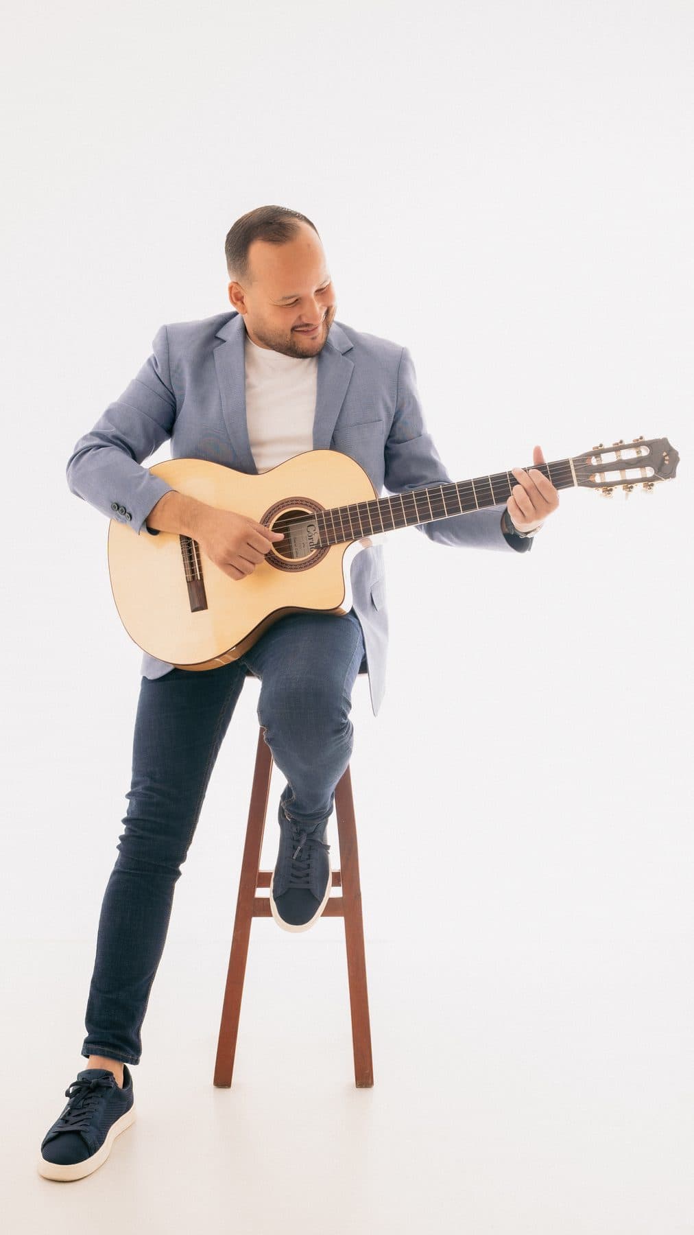 Juan Cañas apoyado en un banco con su guitarra